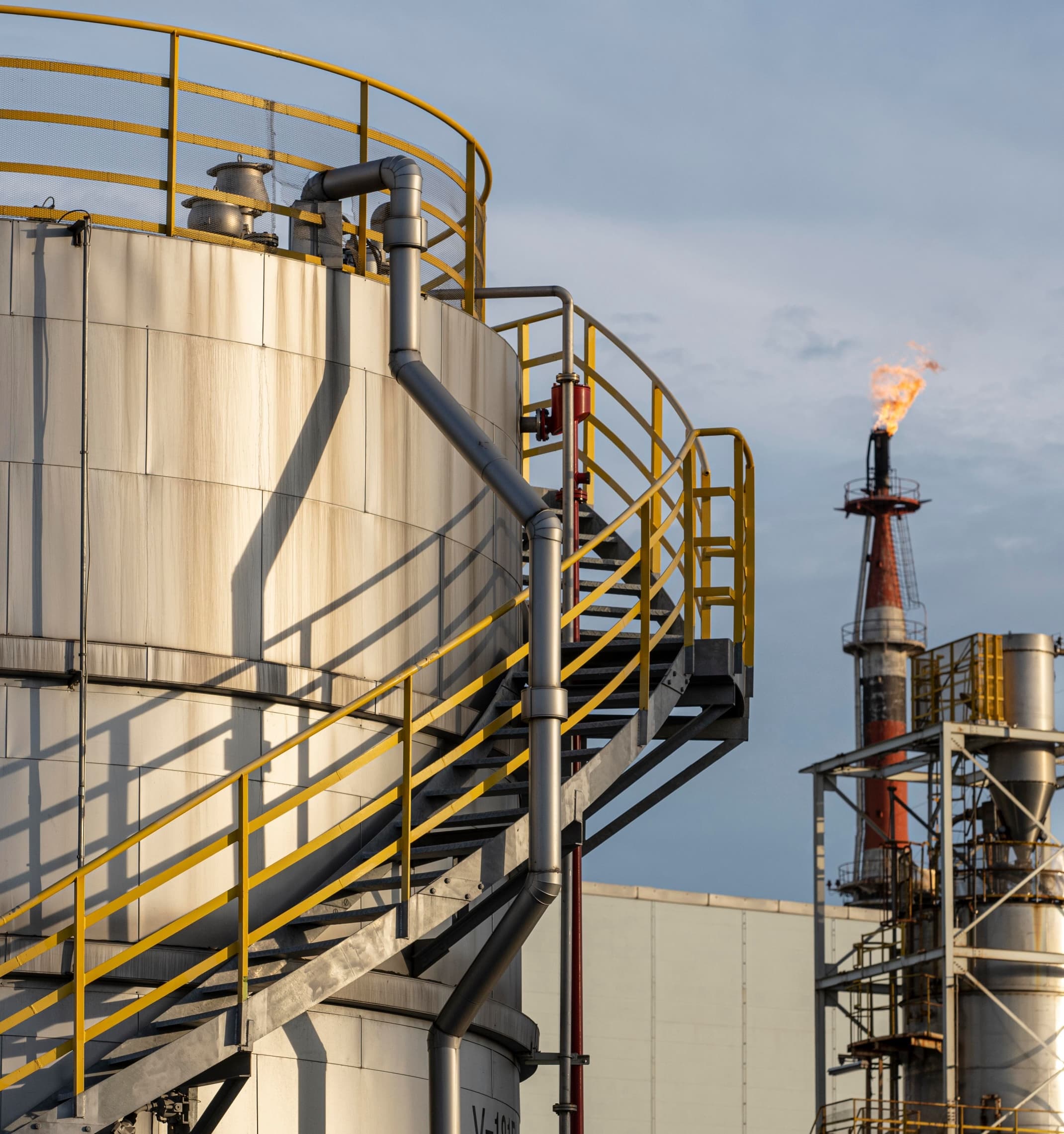 Exterior of an oil and gas refinery flaring gas.