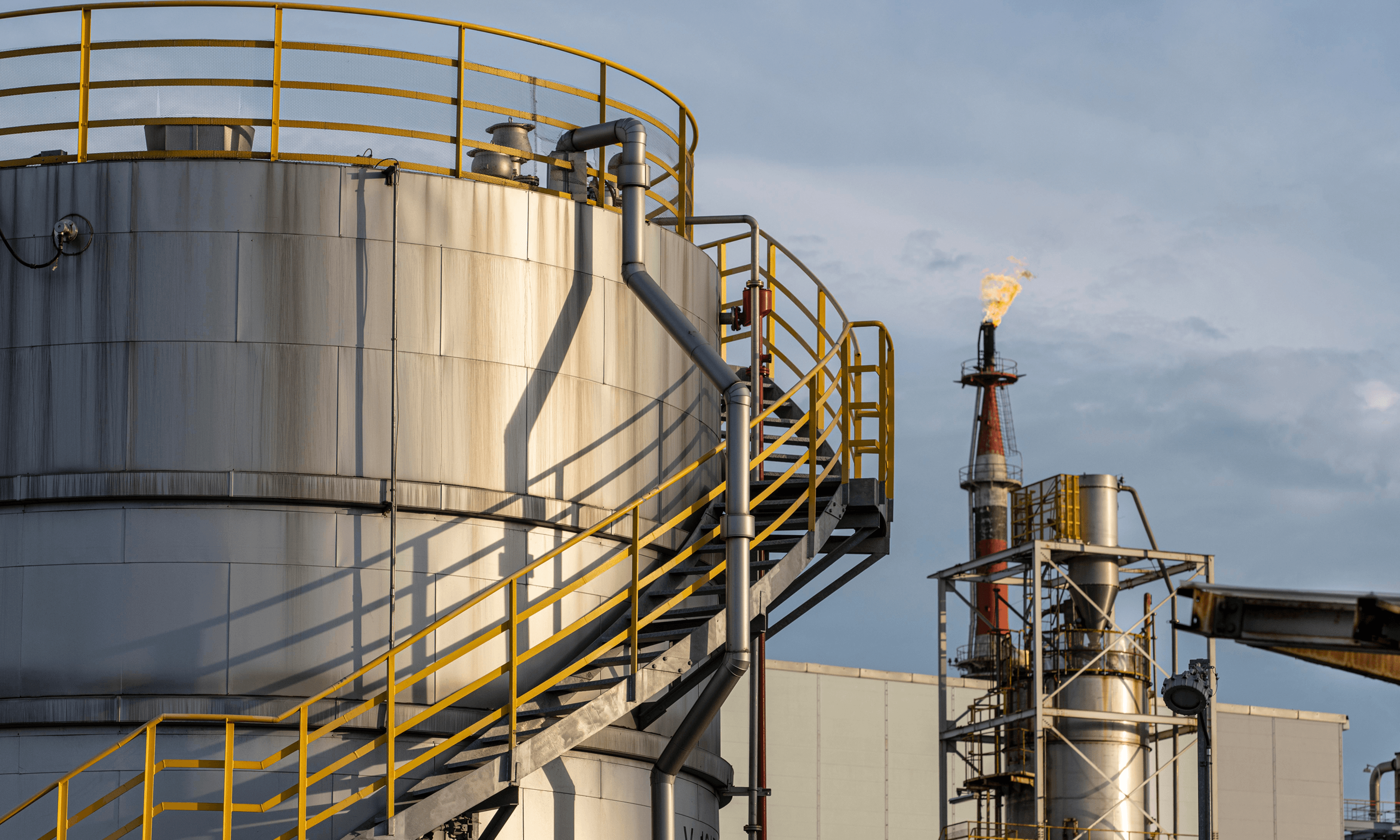 Exterior of an oil and gas refinery flaring gas.