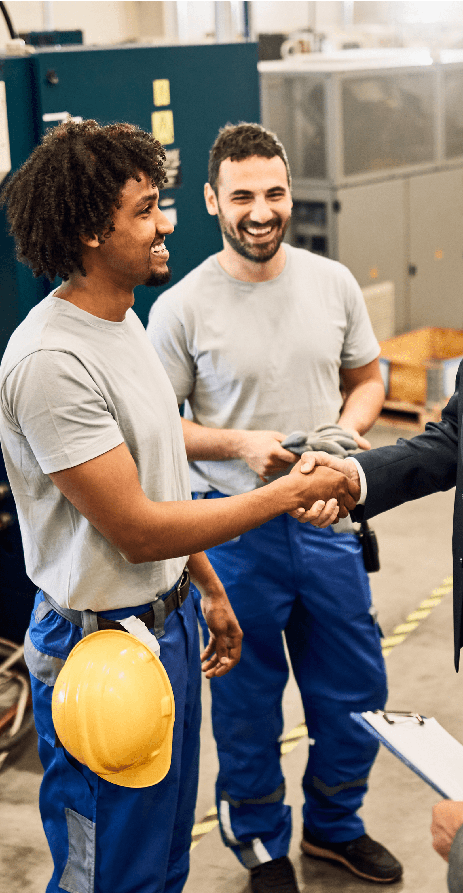 Happy corporate manager shaking hands with worker after staff meeting at factory.